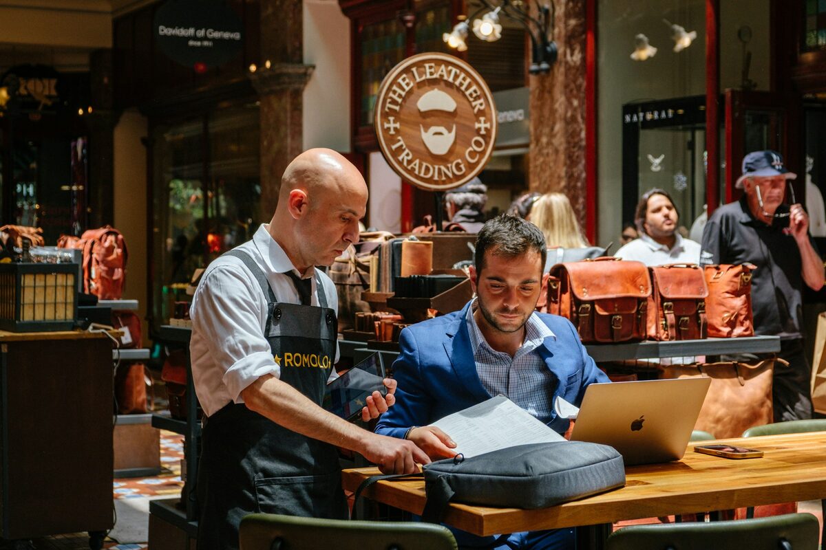 Two people reviewing work on a laptop together in a workshop