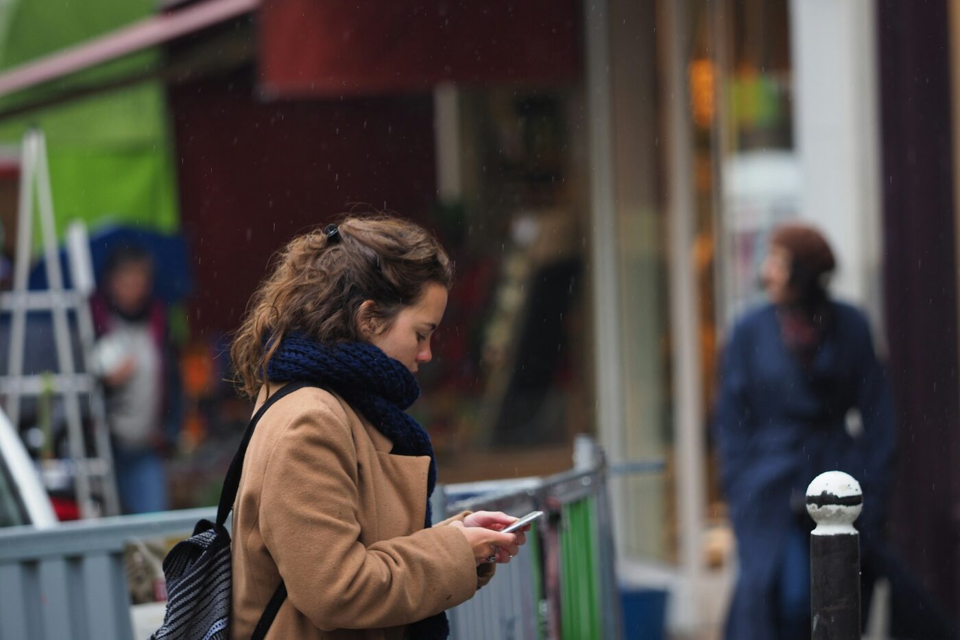 A person using a smartphone on a city sidewalk
