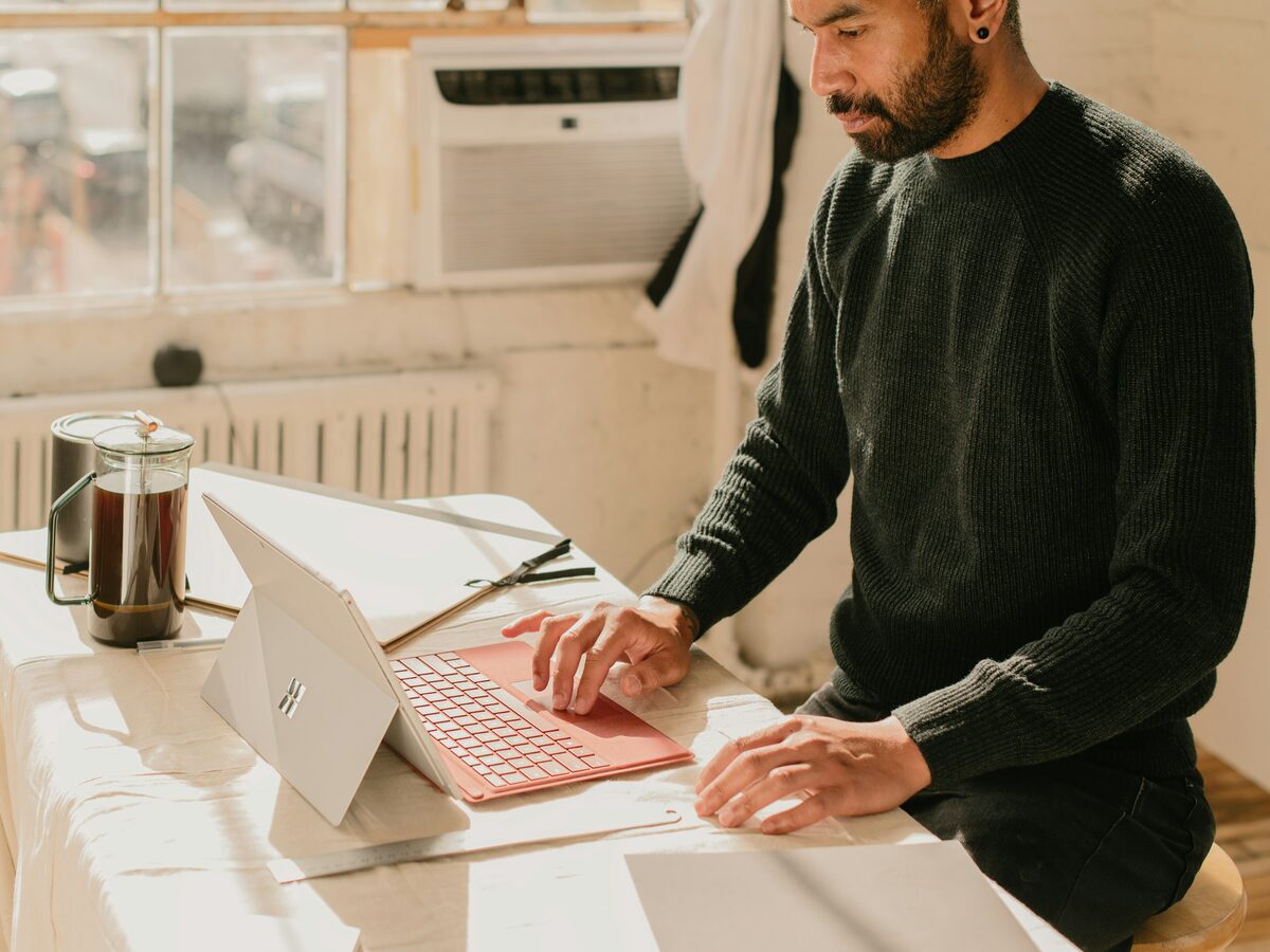 A business owner working at a laptop in a sunlit room