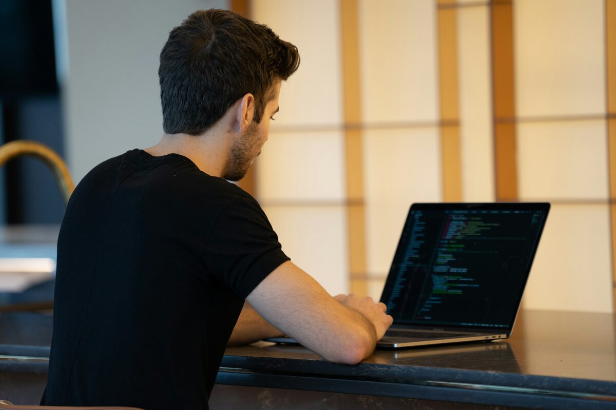 A person working at a laptop beside a window