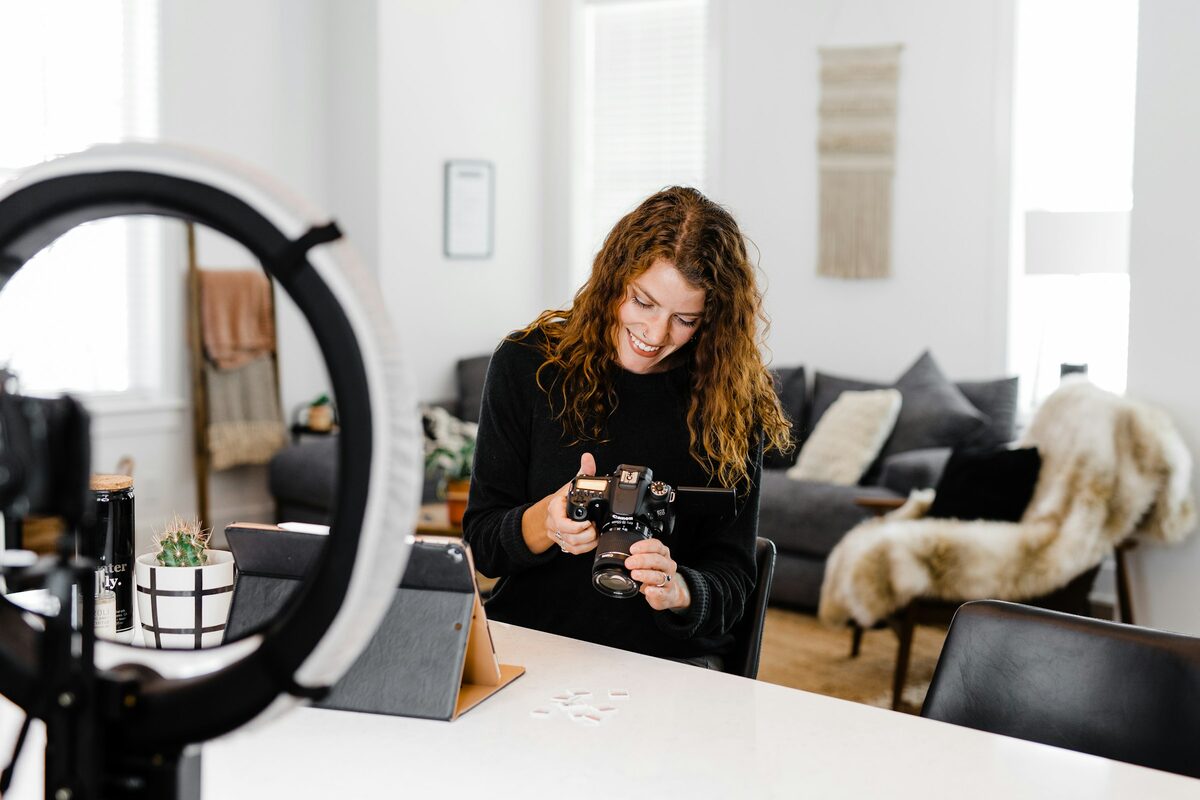 A woman setting up a camera and light to shoot content